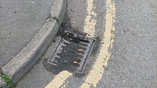 Blocked street drain and double yellow lines